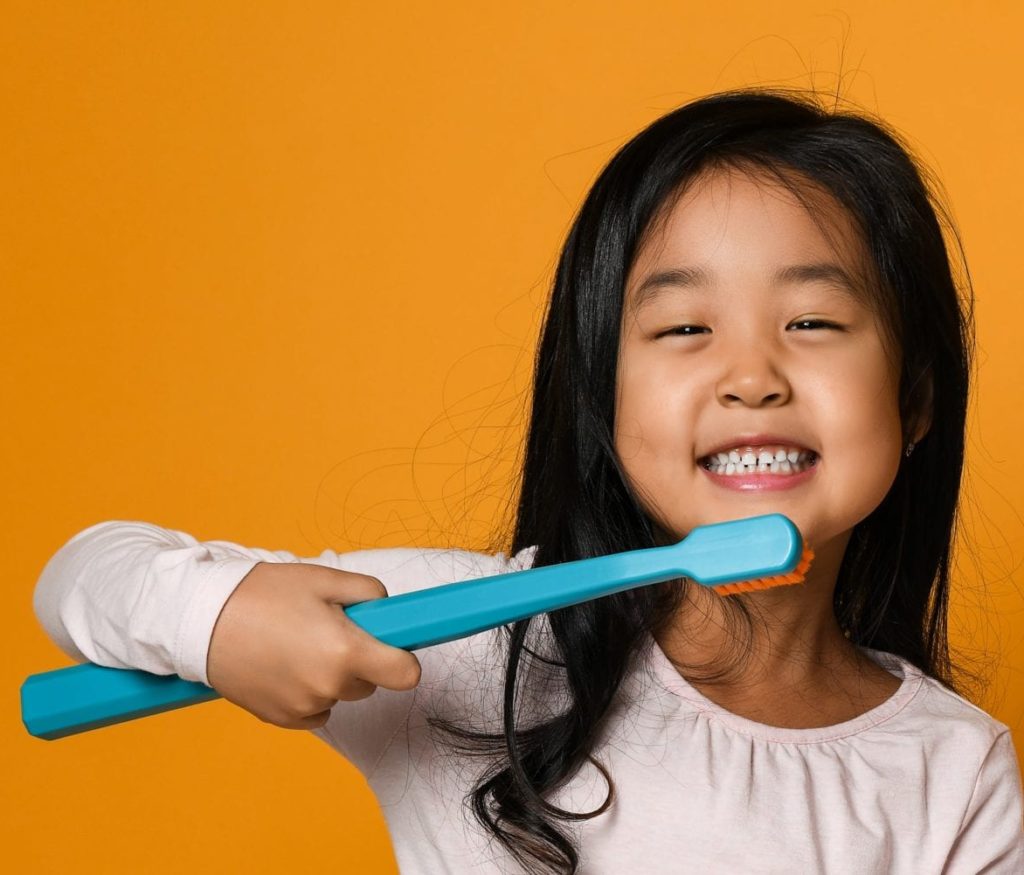 young girl with giant toothbrush