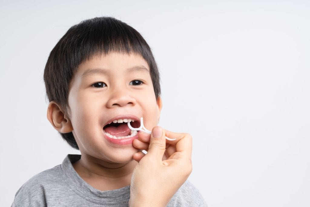 parent flossing kid's teeth