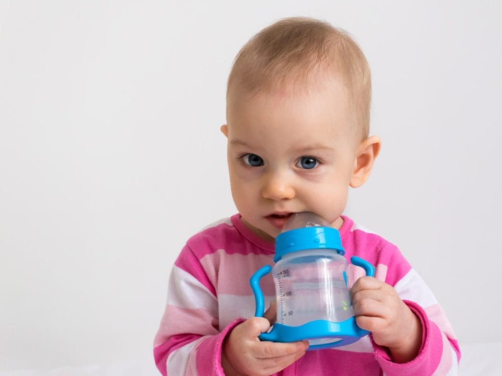 infant with water-filled bottle