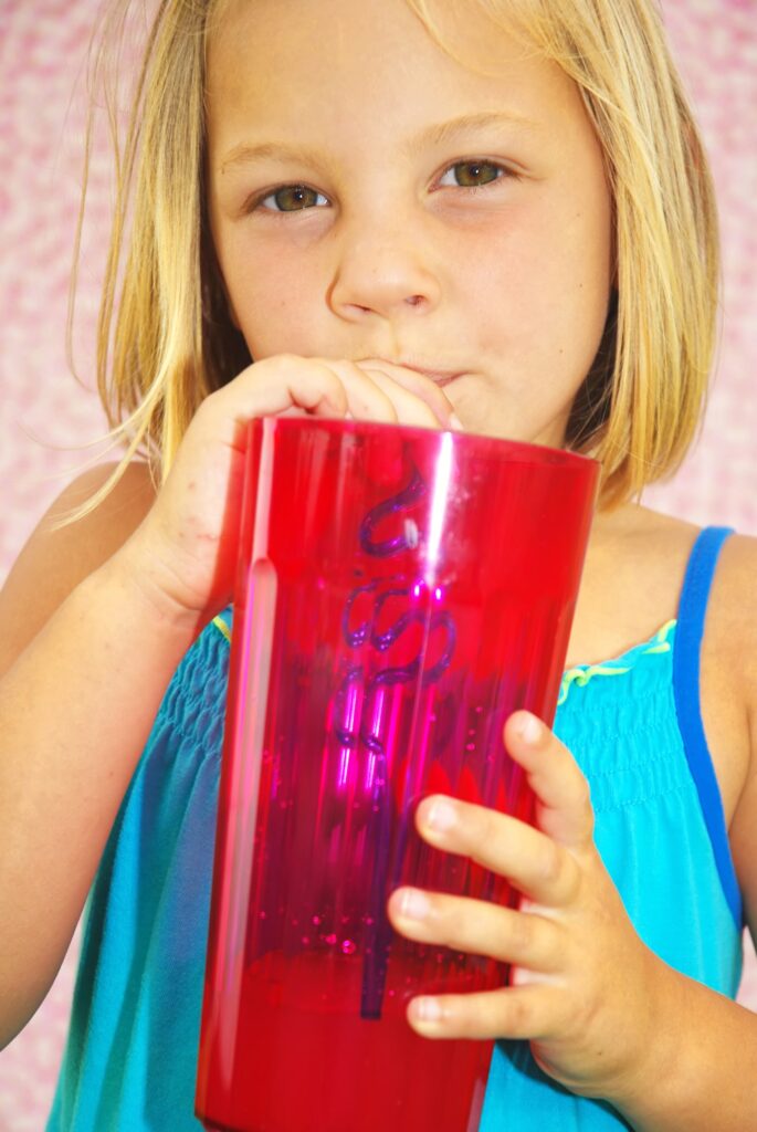 young girl drinking her drink with a crazy straw