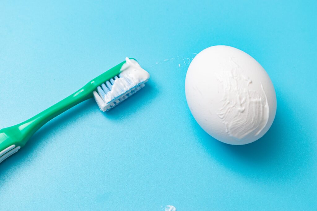 brushing an egg with a toothbrush and toothpaste