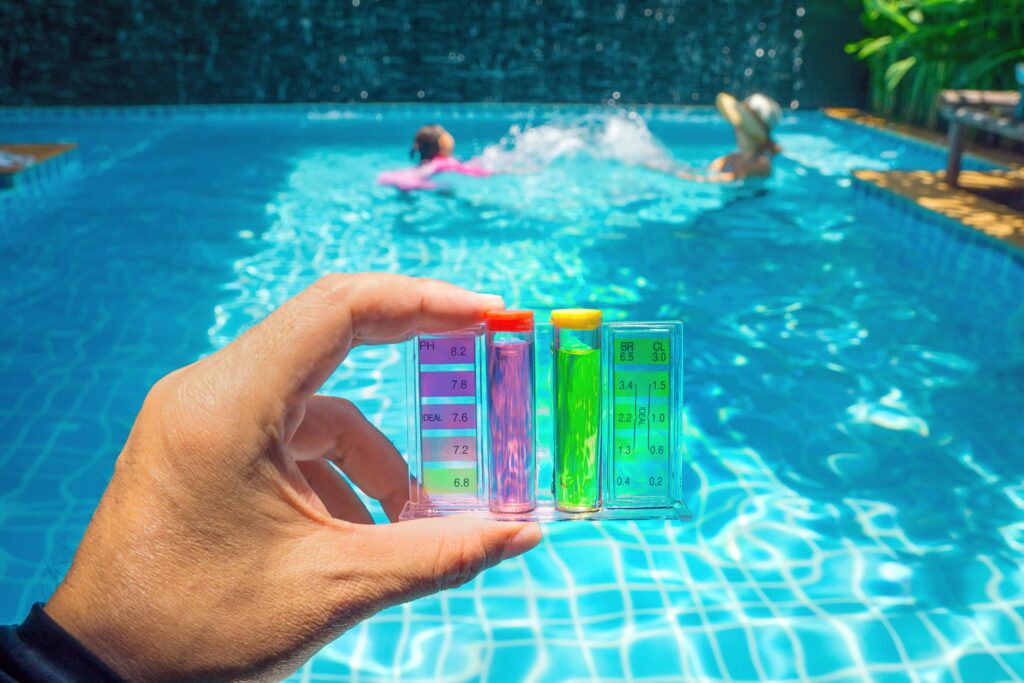 testing pH of swimming pool with mother and child in the background