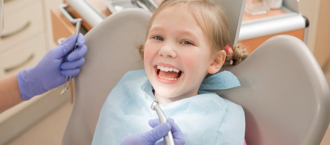 young girl sitting in a dentist chair